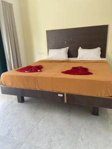 a bed with two red pillows on top of it at Ocean's Edge By Zac in Calangute