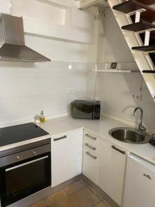 a white kitchen with a sink and a microwave at Altea Serenity in Altea