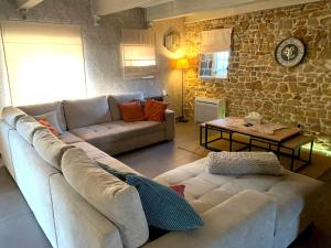 sala de estar con sofá y pared de piedra en 3 bedrooms villa with private pool furnished terrace and wifi at Ohey, en Ohey