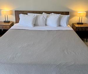a large white bed with white pillows and two lamps at Red Carpet Inn - Houma in Houma