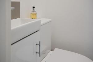 Baño blanco con lavabo y espejo en Stylish 2 Bed with Free Private Parking! en Cheltenham