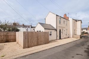 een huis met een hek aan de kant van een straat bij Stylish 2 Bed with Free Private Parking! in Cheltenham