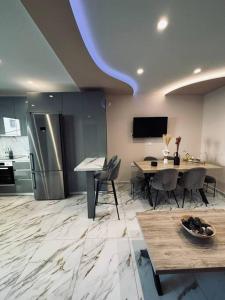 a kitchen with a table and a stainless steel refrigerator at Charming 2-bed house in Kremasti in Kremasti