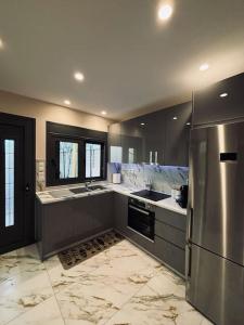 a kitchen with a stainless steel refrigerator and counters at Charming 2-bed house in Kremasti in Kremasti