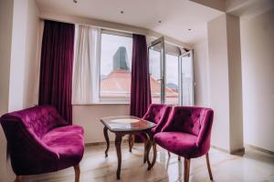 una stanza con due sedie viola e un tavolo e una finestra di Villa Afrodita City Center a Ohrid