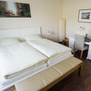 韋斯特博溫的住宿－菲林瓦德魯公寓，卧室配有一张白色的床、一张桌子和一把椅子