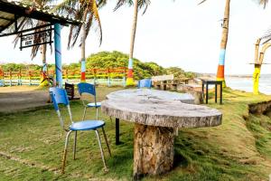 una mesa de madera y sillas en la playa en Hotel EL PALMAR TOURS, en Arboletes