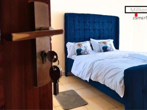 a bedroom with a blue bed with white sheets and pillows at The Chocolate House in Athi River