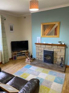 a living room with a couch and a fireplace at Springwell Cottage in Fort William