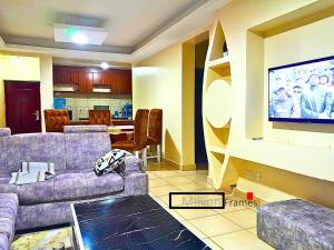 a living room with couches and a flat screen tv at The Chocolate House in Athi River