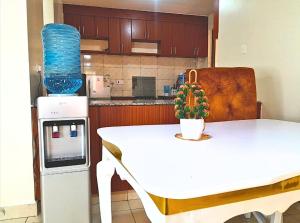 a kitchen with a white table and a table with a vase at The Chocolate House in Athi River