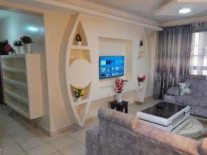 a living room with a couch and a tv at The Chocolate House in Athi River