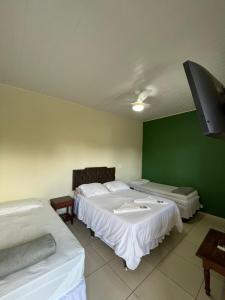 Cette chambre comprend 2 lits et un mur vert. dans l'établissement CHILL INN HOSTEL & POUSADA CENTRO, à Parati