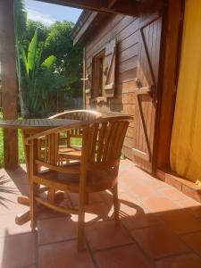 eine Terrasse mit einem Tisch und einem Stuhl auf einer Terrasse in der Unterkunft Lodge Garden in Saint-Pierre