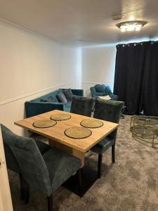 Lovely Two Bedroom Flat في Thamesmead: غرفة مع طاولة وكراسي وأريكة
