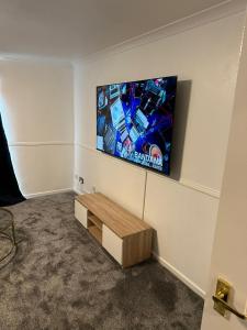 a room with a flat screen tv on a wall at Lovely Two Bedroom Flat in Thamesmead