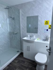 a bathroom with a shower and a toilet and a sink at Clifton Hotel in Scarborough