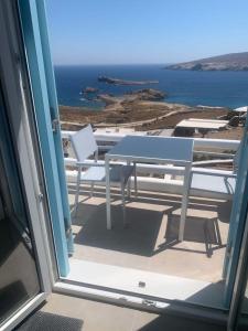 stół i krzesła na balkonie z widokiem na ocean w obiekcie Agean Studio with Breathtaking Views w mieście Agios Sostis Mykonos