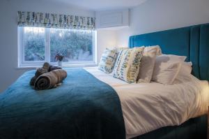 a bedroom with a large bed with pillows and a window at Anchor Well - 2 Bedroom Cottage - Ludchurch in Ludchurch