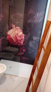 Zimmer mit rosa Rose an der Wand in der Unterkunft Secret Suite in Molfetta