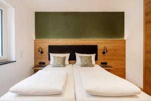 ラーベンスブルクにあるHotel Restaurant Sennerbadの緑の壁のベッドルーム(ベッド2台付)
