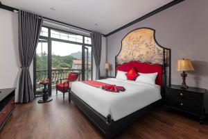 a bedroom with a large bed and a balcony at Indochine Boutique Hotel Ninh Bình in Ninh Binh