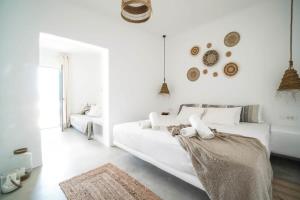 a white bedroom with a white couch and a window at Mykonian Exclusive 3Bd Villa with Private Pool in Mykonos
