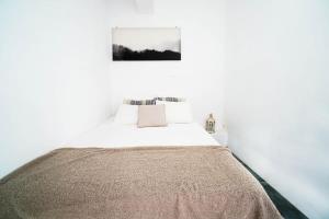 a white bedroom with a bed with a blanket on it at Mykonian Exclusive 3Bd Villa with Private Pool in Panormos Mykonos