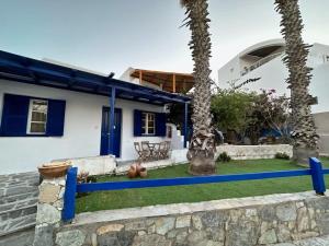 a house with a blue fence in front of a yard at Dreamy Island Escape in Naousa Paros in Naousa