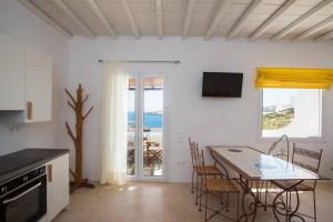 a kitchen and dining room with a table and chairs at Amazing Views At Agios Sostis Beach In Mykonos in Agios Sostis Mykonos