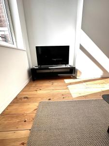 uma sala de estar com uma televisão de ecrã plano num piso de madeira em Appartement Lille Centre 4 personnes em Lille