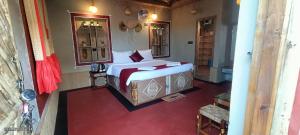 a bedroom with a large bed with a red floor at Gharana Resort in Singur