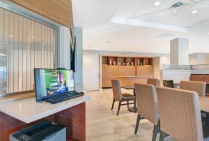 TownePlace Suites by Marriott Jackson Airport/Flowood في فلووود: مكتب مع لاب توب على مكتب مع كراسي