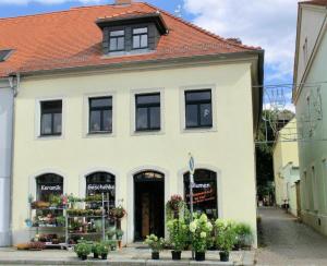 un edificio blanco con una floristería delante en Kirchblick, en Radeburg