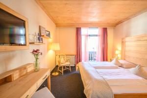 a hotel room with a bed and a tv at Biohotel Garmischer Hof in Garmisch-Partenkirchen