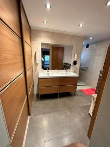 uma casa de banho com um lavatório e um espelho grande em Chez Tangs em Liège