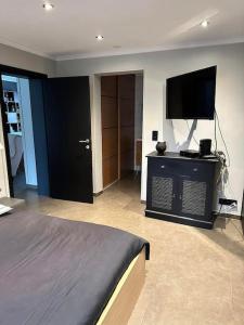 - une chambre avec un lit et une télévision à écran plat dans l'établissement Chez Tangs, à Liège