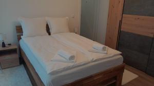 1 dormitorio con 1 cama con 2 toallas en Spa Koncept-Apartmani en Veliko Gradište