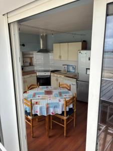a kitchen with a table with two chairs and a refrigerator at L'Imprenable vue mer in Crozon