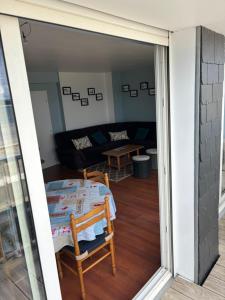 a living room with a table and a couch at L'Imprenable vue mer in Crozon