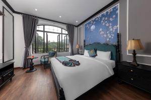 寧平的住宿－Indochine Boutique Hotel Ninh Bình，一间卧室设有一张大床和一个窗户。
