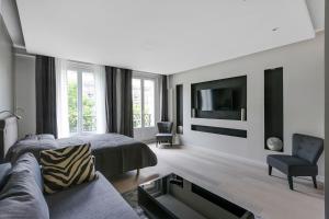 a living room with a couch and a tv at Blue Nights Apartments - Sébastopol in Paris