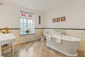 a bathroom with a tub and two sinks and a toilet at Two Bridges Hotel in Two Bridges