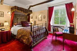 a bedroom with a canopy bed and a red carpet at Two Bridges Hotel in Two Bridges