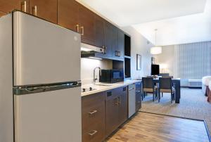 a kitchen with a refrigerator and a dining room at TownePlace Suites by Marriott Jackson Airport/Flowood in Flowood