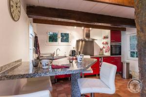 cocina con encimera de granito y armarios rojos en Maison de 4 chambres avec jardin clos et wifi a AnnebaultA, en Annebault