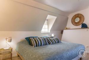 1 dormitorio con cama con sábanas azules y ventana en Maison de 4 chambres avec jardin clos et wifi a AnnebaultA, en Annebault
