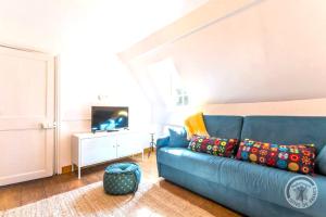 sala de estar con sofá azul y TV en Maison de 4 chambres avec jardin clos et wifi a AnnebaultA, en Annebault