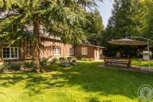 una casa con un patio con un banco y una sombrilla en Maison de 4 chambres avec jardin clos et wifi a AnnebaultA, en Annebault