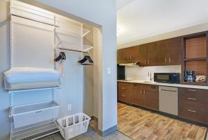 une cuisine avec des placards en bois et un dressing dans l'établissement TownePlace Suites by Marriott Jackson Airport/Flowood, à Flowood